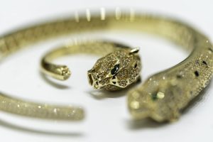 a gold bracelet with diamonds and a tiger head