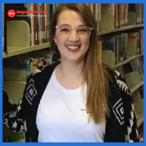 Sarah Ziolkowska, in glasses, poses in front of bookshelves in Library, symbolizing her professional career and work life.