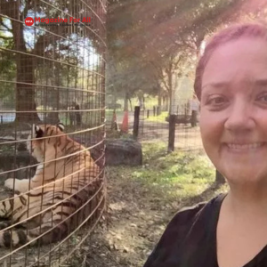 Jamie Veronica Murdock stands beside a tiger, showcasing a moment of connection between humans and wildlife.