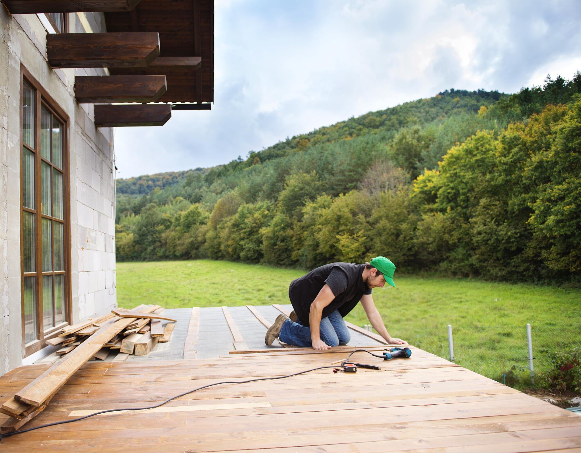 Handyman,Installing,Wooden,Flooring,In,Patio,,Working,With,Drilling,Machine