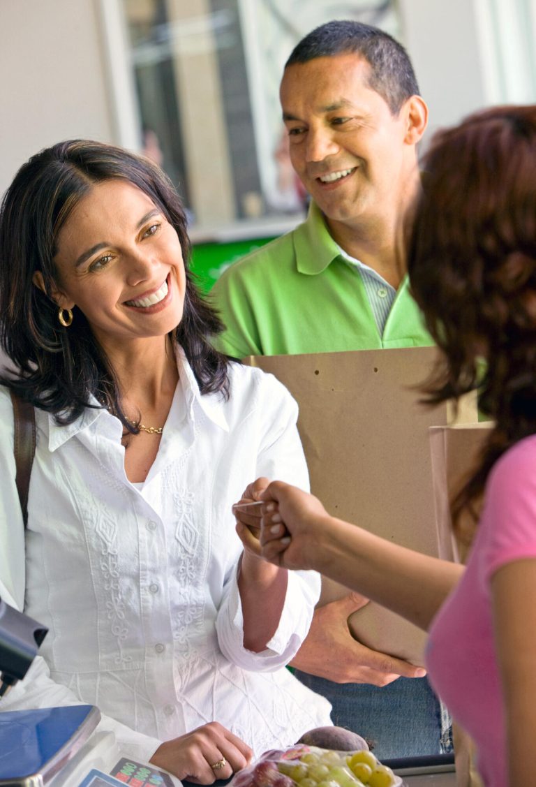 Beautiful,Couple,Smiling,-,A,Supermarket,Checkout,With,Shopping,Till